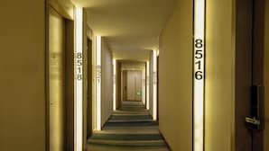 Een hotelgang met nummers op de muren die kamer nummers aangeven.