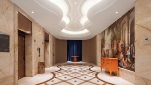 A lobby with a marble floor, a central table, and a painting on the wall. - Four Seasons Fashion Hotel (Yongkang South Railway Station Xijinqiao Pedestrian Street) (Yongkang)