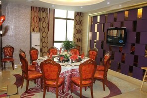 A conference room with a round table, chairs, and a television. - Lanzhou Senheyuan Hotel (Lanzhou)