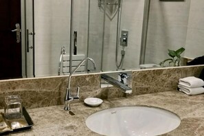A bathroom with a sink, mirror, towel rack, and shower. - Lanzhou Senheyuan Hotel (Lanzhou)
