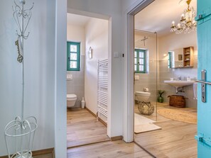 Bathroom features a bathtub, sink, and toilet, with a towel rack and chandelier.