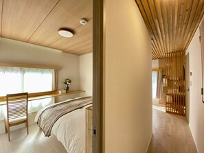 Cozy retreat with a large bed, wooden desk, and comfortable seating area.