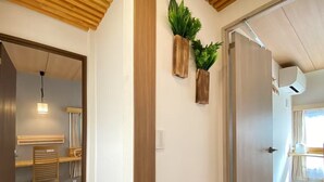A hallway with a wooden floor, a desk with a chair, and two wall-mounted planters with green plants. - N52#[NEW] Tokyo comfortable guest rooms / direct access to Akihabara and Shinjuku / 8 min walk from JR Shinkoiwa station / convenient access to Narita & Haneda Airport (江戸川区)