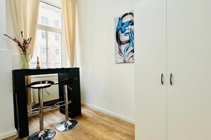 Una habitación con ventana, un cuadro, un radiador y un armario.