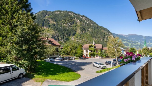 A residential area with a street view, parked cars, and houses with visible architecture. - Apartment Rosa by Interhome (Mayrhofen)