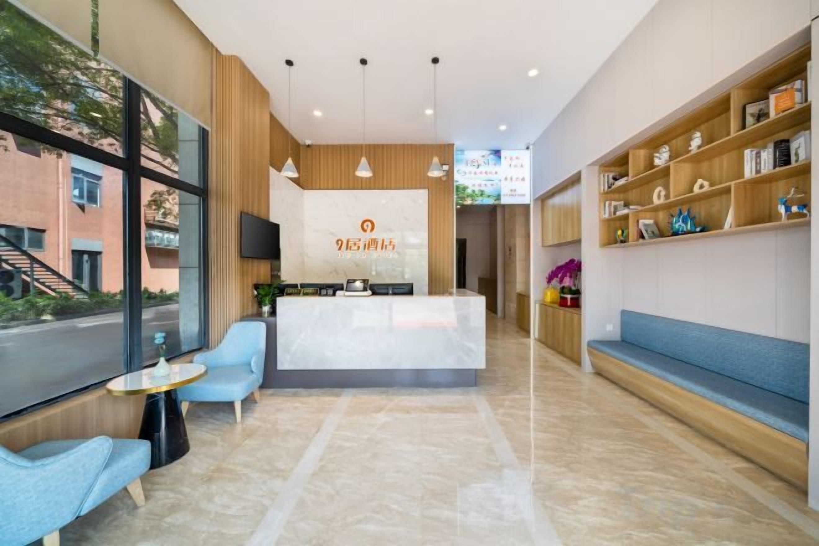 A reception area with a reception desk, seating, and a view of the outdoors.