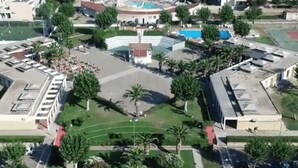 An aerial view of a residential area with a central courtyard, surrounded by buildings and palm trees. - La Conchiglia  - Piscina e Animazione gratuita (Bernalda)