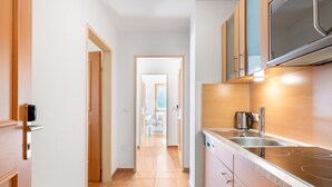 A modern kitchen with a built-in microwave, stainless steel sink, and a granite countertop.