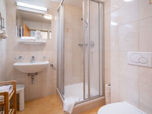 Enjoy a refreshing shower with a clear view of the floor, a sink with a faucet, and a vanity with a mirror.