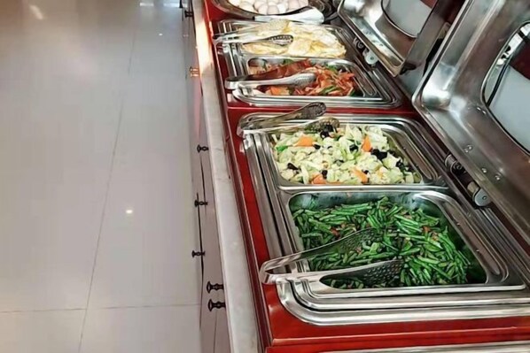 A buffet with multiple food stations including salads, vegetables, and meats.