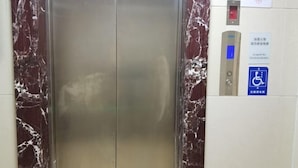 An elevator with marble walls and a control panel with a wheelchair accessibility sign. - Xicui Hotel (Beijing Baizhifang) (Beijing)