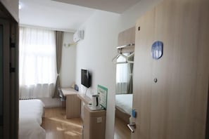 A hotel room with a bed, a desk with a chair, a TV, and a small kitchenette. - Xicui Hotel (Beijing Baizhifang) (Beijing)