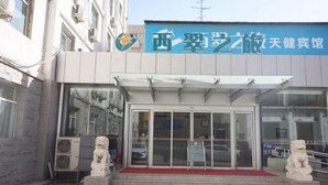 A building with a blue sign reading "西翠艺术旅天健宾馆". - Xicui Hotel (Beijing Baizhifang) (Beijing)