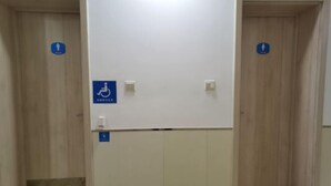 A restroom with two doors, each marked with a wheelchair accessibility sign. - Xicui Hotel (Beijing Baizhifang) (Beijing)