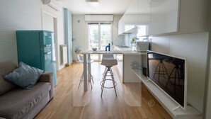 A modern kitchen with a dining area, a sofa, and a TV. - In an enchanting location, in a residential neighborhood a stone's throw from the city center and directly in the territory of the Marine Protected Area Torre del Cerrano, the I Gabbiani residence will offer you a relaxing holiday. The three-room apart (Foggetta)