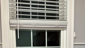 A kitchen with a stainless steel sink, a window with blinds, and a potted plant with red flowers on the windowsill. - North End Relaxing Family (Manchester)