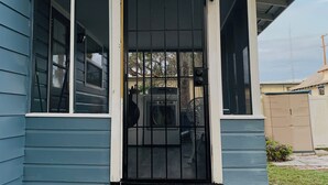 A house with a front porch, a black door, and a small set of steps leading up to the entrance. - The Studio on 8th, Entire guest suite in Wauchula Florida ! (Wauchula)