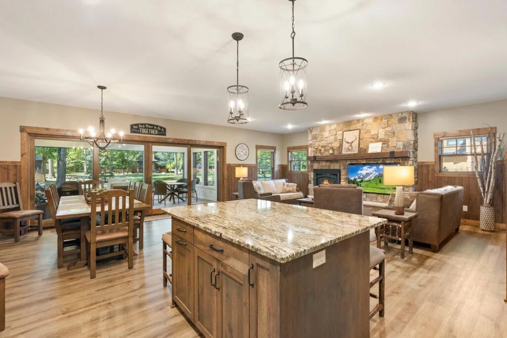 A spacious kitchen with a large island, wooden cabinetry, and a stone accent wall.