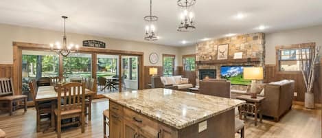A spacious kitchen with a large island, wooden cabinetry, and a stone accent wall.