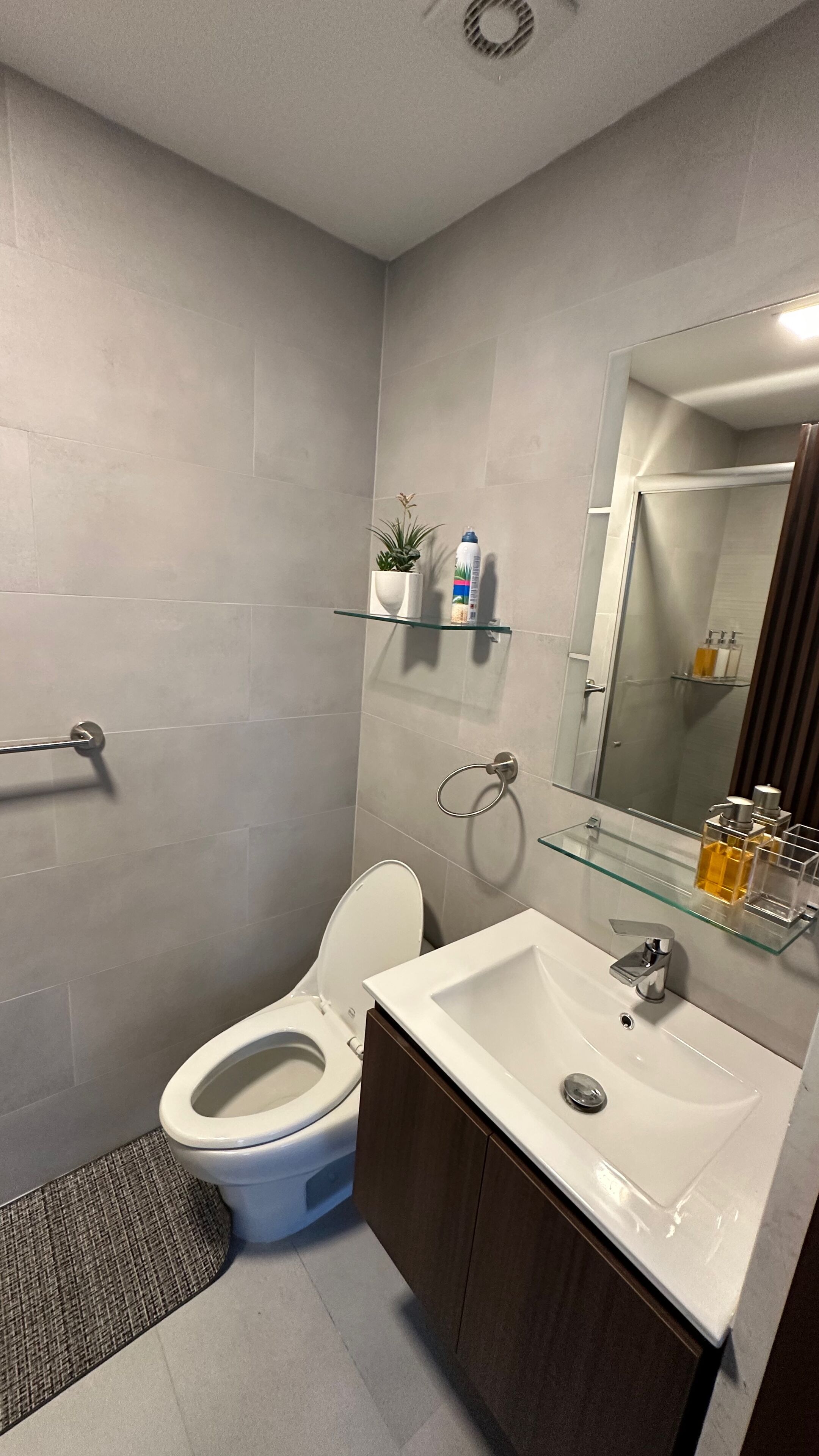 A modern bathroom with a toilet, sink, and shower area.