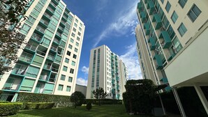 Ein modernes Hochhaus mit mehreren Balkonen und einem gepflegten Gartenbereich.