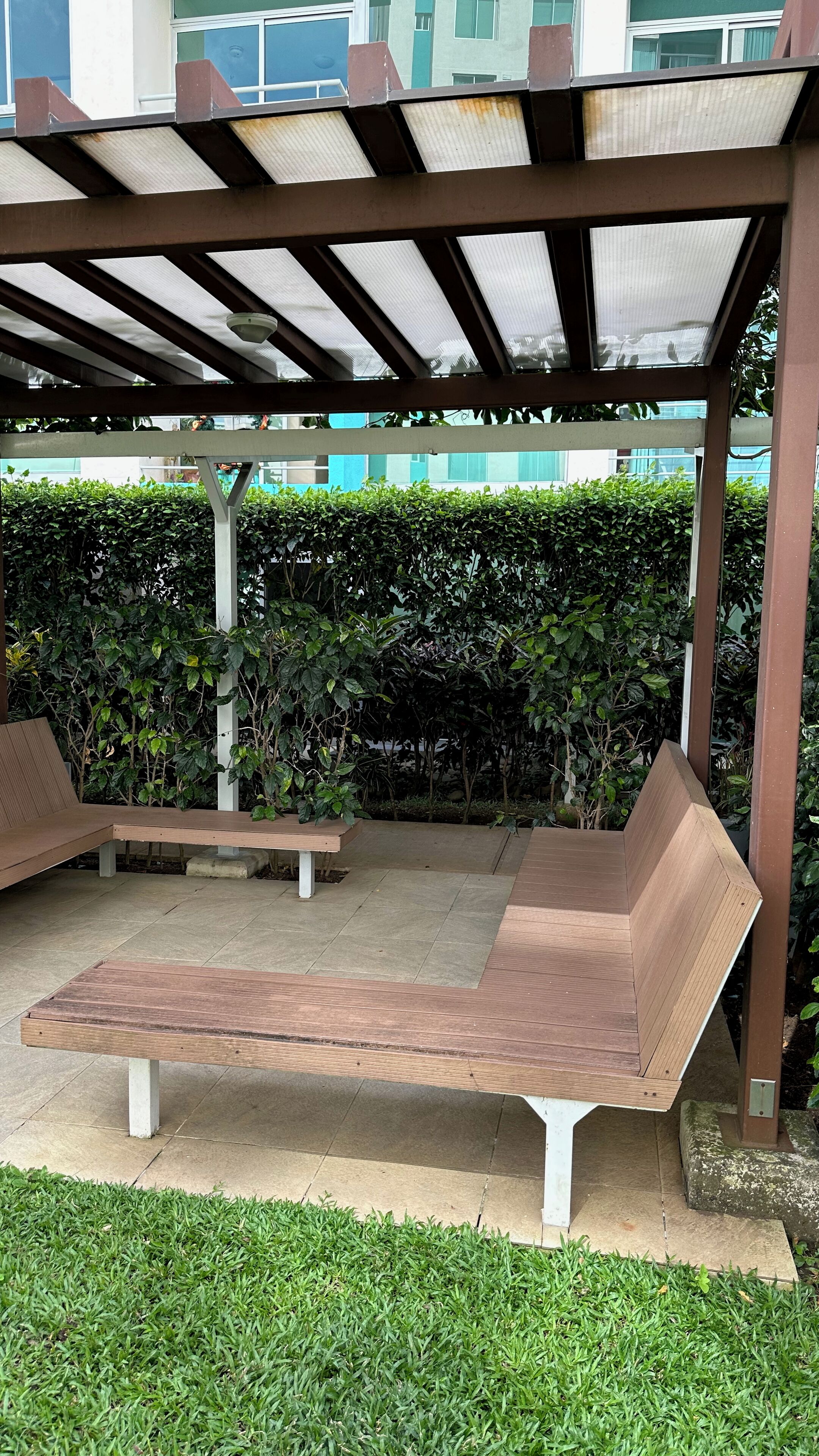 Un área de estar al aire libre con bancos y una estructura de pérgola.