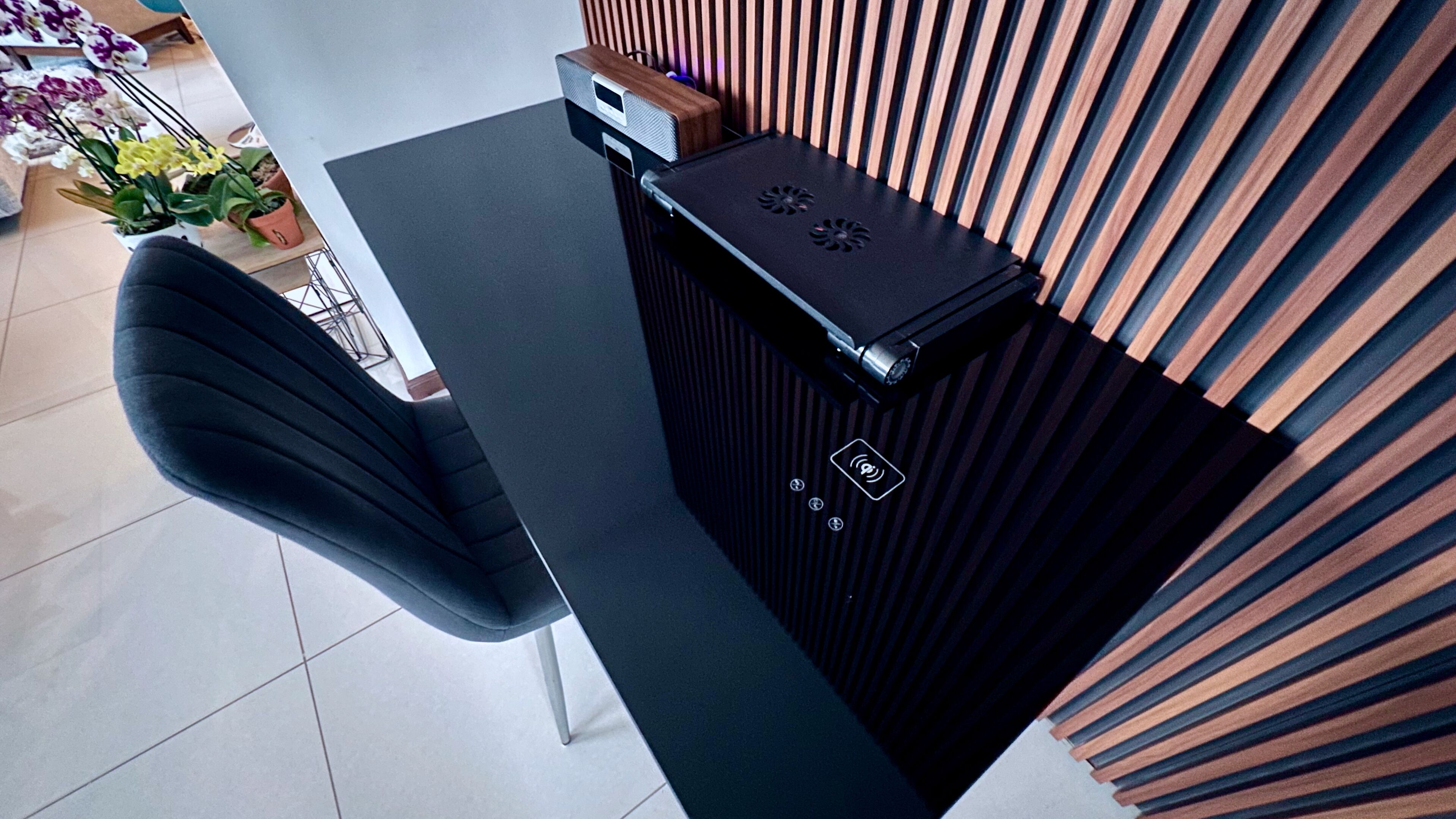 A reception desk with a black surface, a speaker, and a control panel with a Wi-Fi symbol.