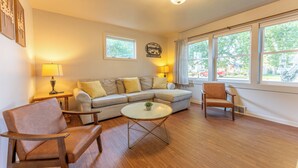 A living room with a sectional sofa, two armchairs, a coffee table, and a fireplace. - Ely Basecamp- Perfect for Families and Groups (Ely)