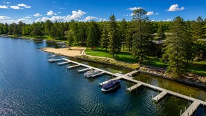 Un port de plaisance avec des quais, un bateau et, au loin, un terrain de golf.