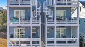 A multi-level house with balconies, staircases, and a clear view of the surrounding area.