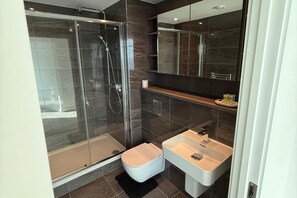 Kombinert dusj/badekar, dype avslapningsbadekar og håndklær