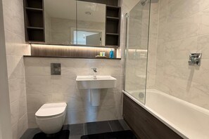 Combined shower/bathtub, deep-soaking bathtub, towels, toilet paper