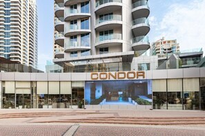 A modern building with a prominent 'CONDOR' sign, featuring a glass facade and a central atrium.