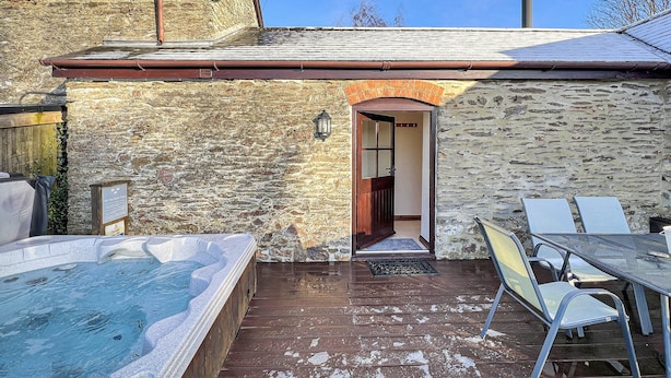 A stone building with a wooden deck, a hot tub, and a table with chairs. - The Cider Barn, Waterrow, Nr Wivelsicombe (Waterrow)
