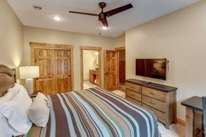 Relax in this inviting bedroom with a large bed and a mounted TV, plus a dresser for your belongings.
