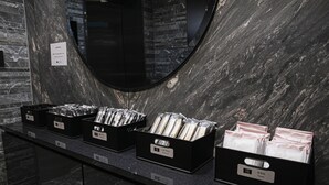 A bathroom with a marble countertop, a mirror, and three black boxes labeled with different amenities. - HOTEL NOIR Kagoshima Chuo Station (Kagoshima)