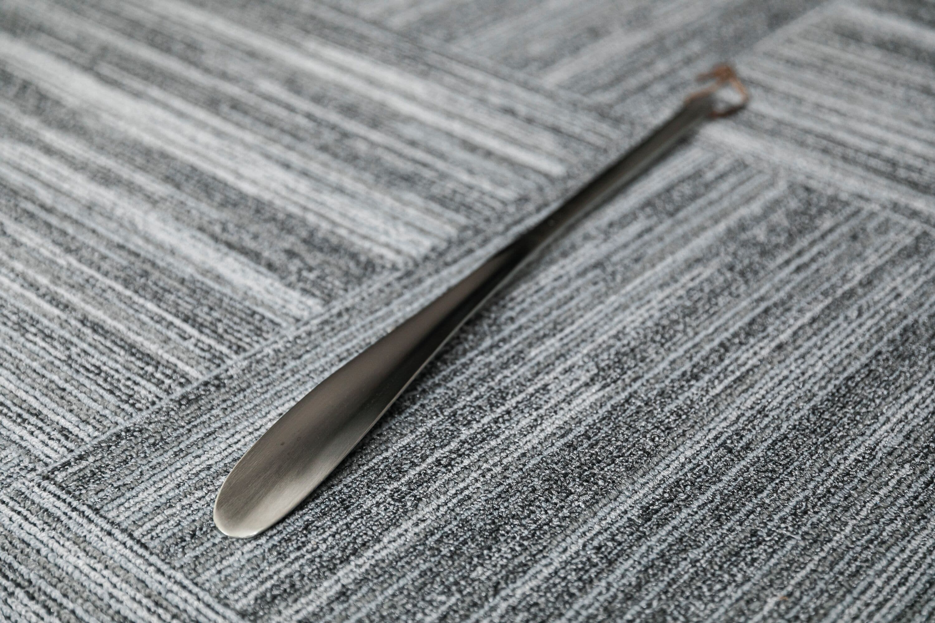 A textured fabric surface with a metallic spoon.