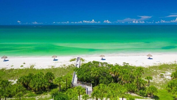 A beach with clear turquoise water, white sand, and green vegetation. - Walk to Lido Beach Tiki Bar, 2 Queen Suites (Sarasota)