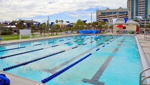 A swimming pool with multiple lanes, a covered area, and a building in the background. - Walk to Lido Beach Tiki Bar, 2 Queen Suites (Sarasota)