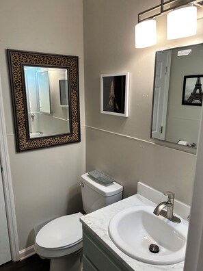 Ein Badezimmer mit Toilette, Waschbecken und zwei Spiegeln.