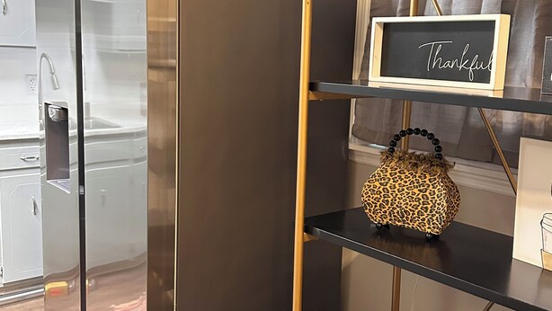 Una cocina moderna con electrodomésticos de acero inoxidable, una estantería de madera y un letrero que dice 'Thankful'.