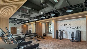 A gym with exercise equipment, a mirror, and a motivational wall saying 'NO PAIN NO GAIN'. - Luxe Interior Studio in Pantheon Elysee 3 in JVC (Dubai)