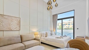 A hotel room with a bed, a sofa, a table, and a large window with a view of buildings. - Luxe Interior Studio in Pantheon Elysee 3 in JVC (Dubai)