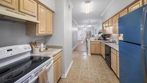 Una cocina moderna con armarios de madera, un refrigerador de acero inoxidable y un horno empotrado.