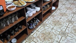 A buffet setup with various food items and a water dispenser. - Vazira Hotel (Samarkand)