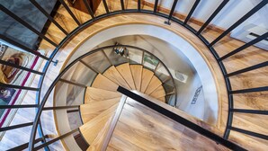A spiral staircase with wooden steps and black metal railings. - New! Lake Access, Pools/Hot Tub & Ski Area Proximity (Whitefish)