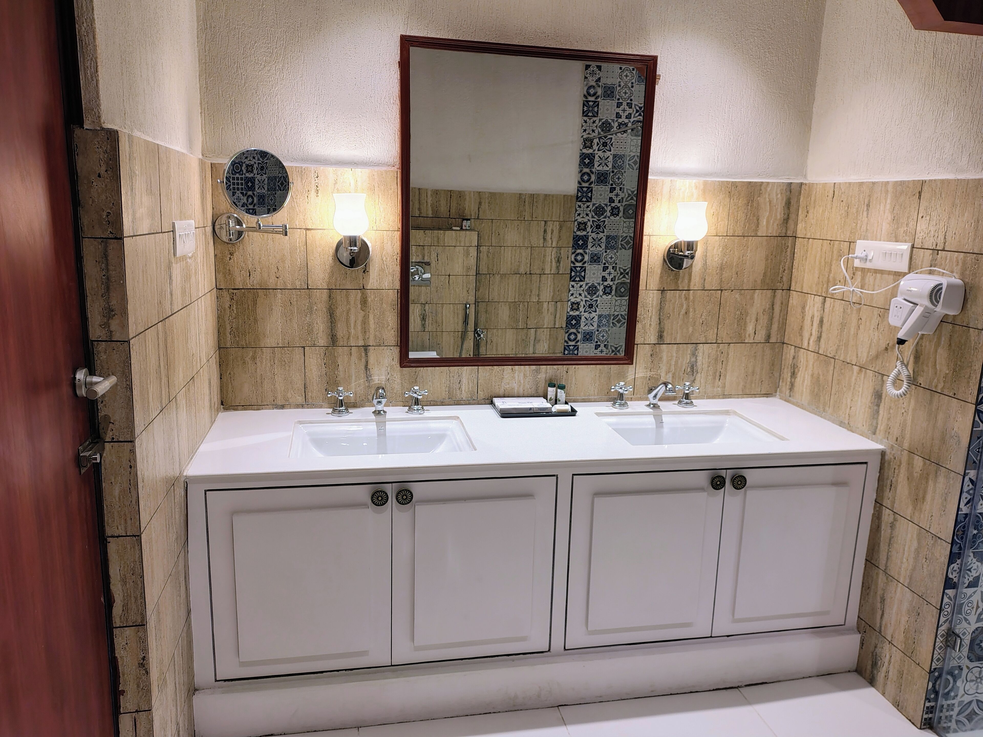 A bathroom with a double sink vanity, a mirror, and a towel rack.