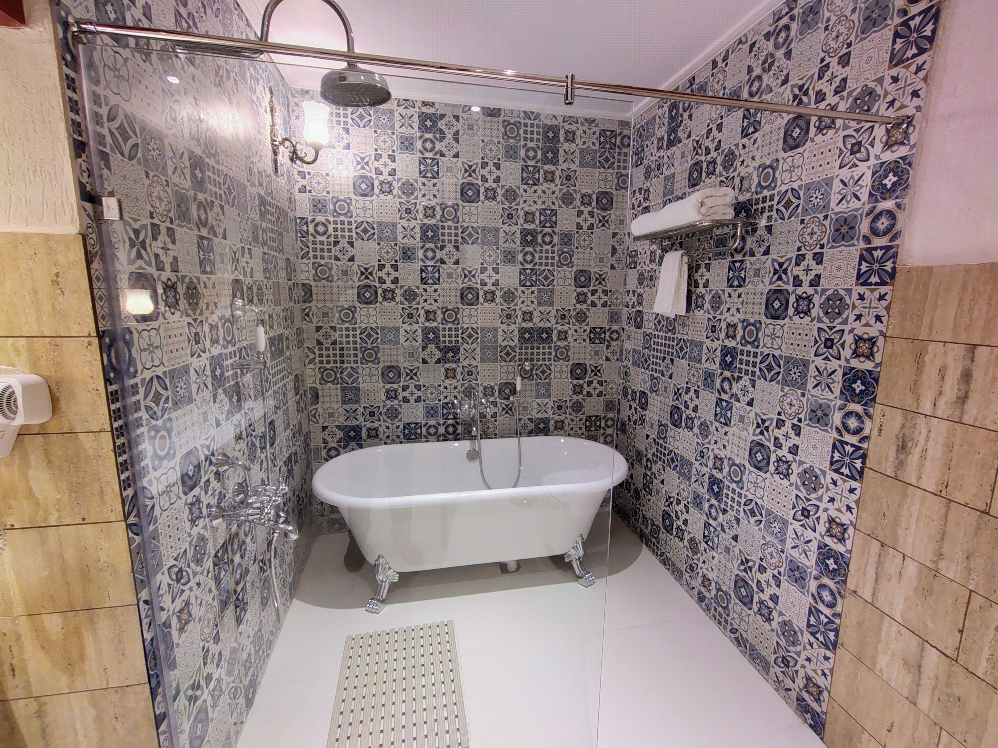 A bathroom with a freestanding bathtub, a showerhead, and a towel rack.