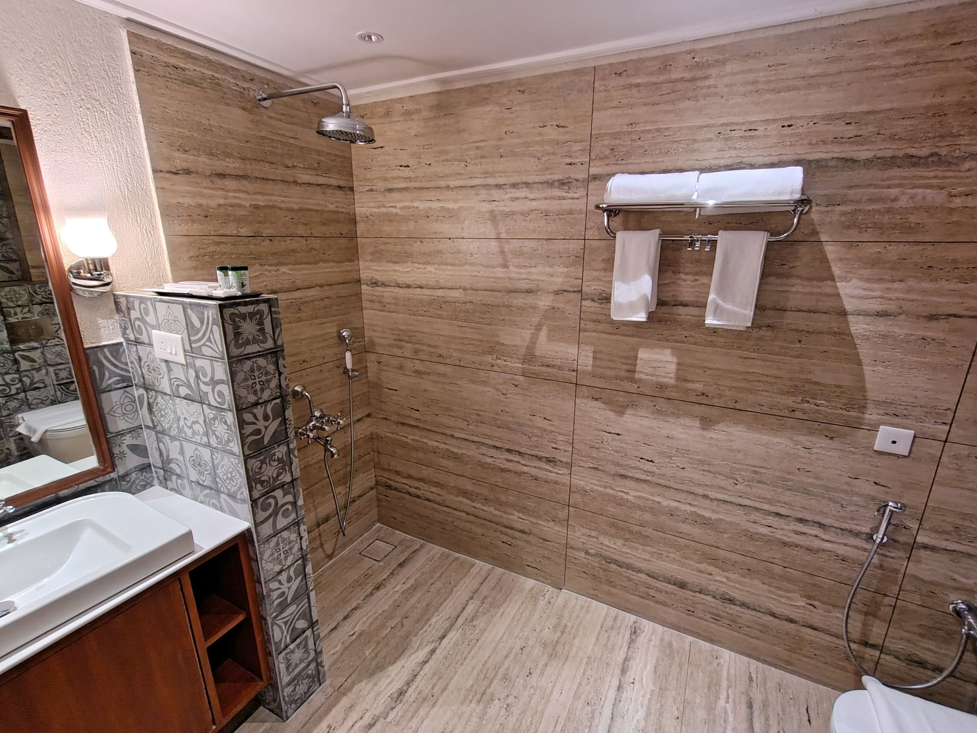 Een moderne badkamer met een douche, wastafel en spiegel.