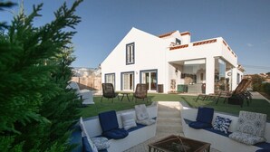 Une maison moderne dotée d’un patio comprenant un ensemble de canapés, des fauteuils et une table.
